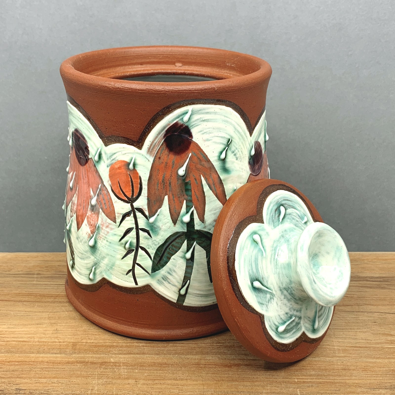 Handmade ceramic jar with lid by NC pottery Amy Irish. Jar is decorated with coneflowers. Available at larkandkey.com, Charlotte NC.
