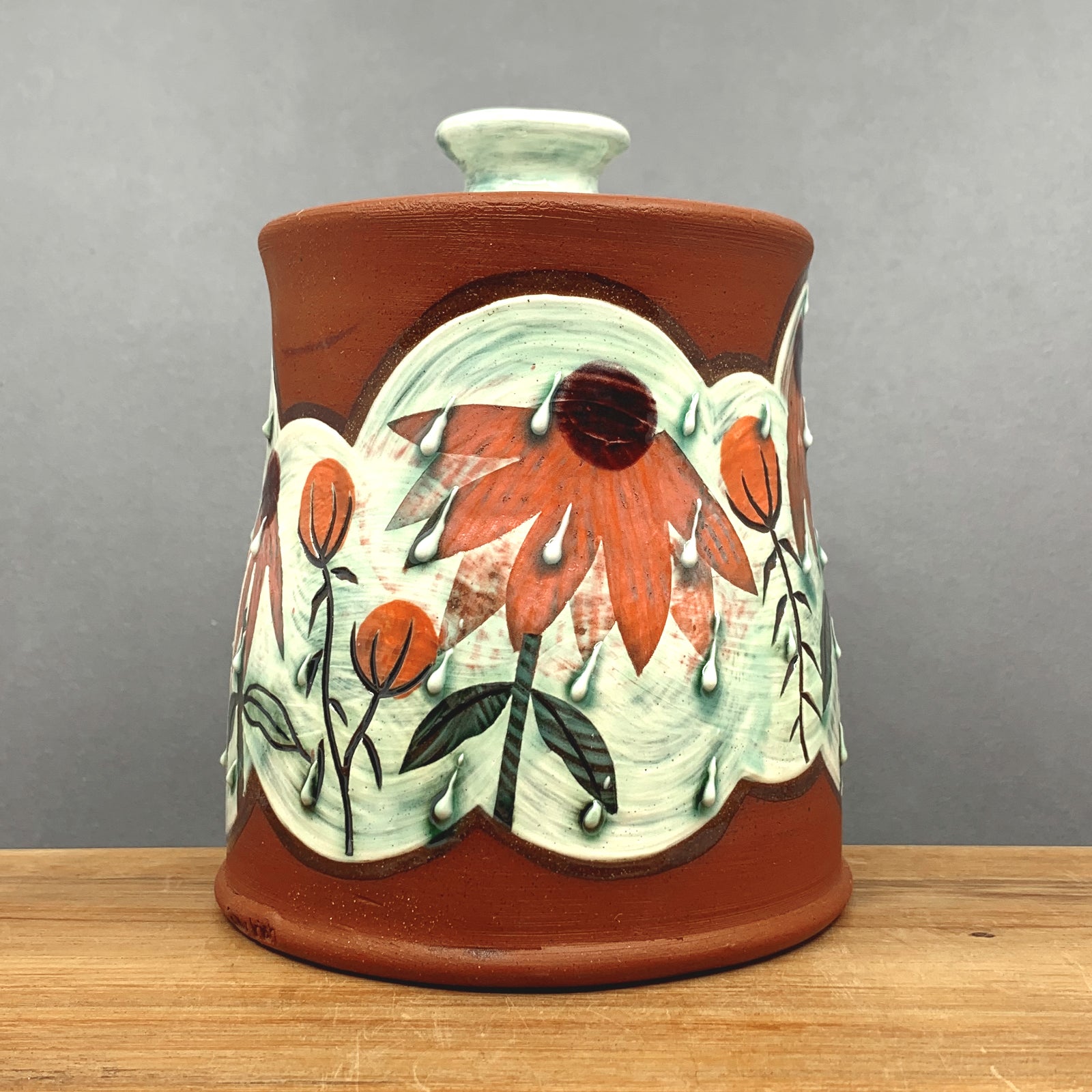 Handmade ceramic jar with lid by NC pottery Amy Irish. Jar is decorated with coneflowers. Available at larkandkey.com, Charlotte NC.