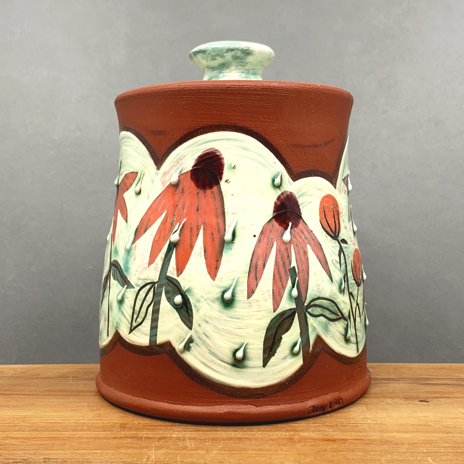 Handmade ceramic jar with lid by NC pottery Amy Irish. Jar is decorated with coneflowers. Available at larkandkey.com, Charlotte NC.