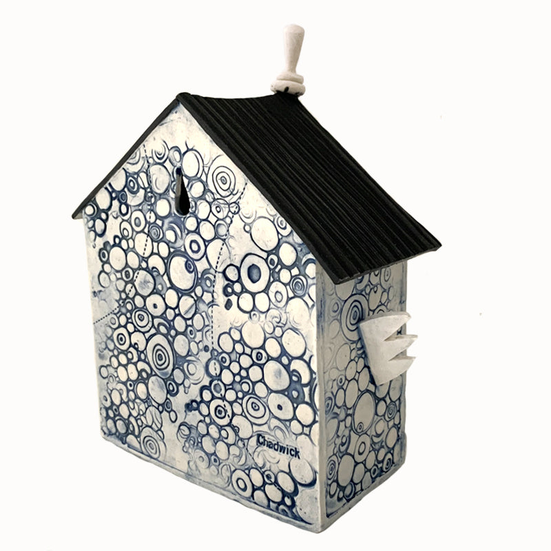 Handmade ceramic house by artist Barbara Chadwick, white with blue circle pattern and dragonfly. Back view.