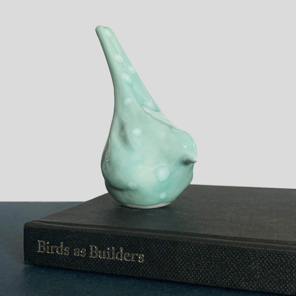 Small ceramic sculpture of a bird, glazed in an aqua blue crystalline glaze, by artist Becky Story.