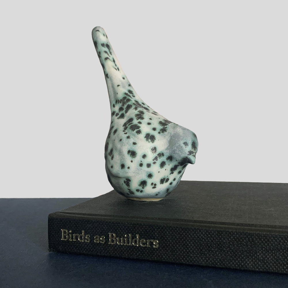 Small, hand sculpted ceramic bird glazed in a cream, pale bluish green and dark gray color by artist Becky Story.
