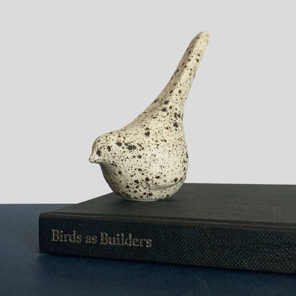Small hand sculpted ceramic bird, cream with dark speckled pattern, by Beck Story.