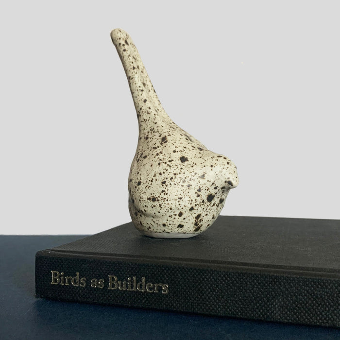 Small hand sculpted ceramic bird, cream with dark speckled pattern, by Beck Story.