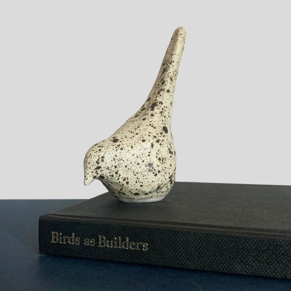 Small hand sculpted ceramic bird, cream with dark speckled pattern, by Beck Story.
