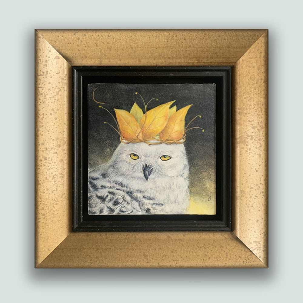 "Autumn Coronation" painting by Diane Savino. A snow owl wears a crown of golden leaves, with a sliver of the moon showing in a dark sky. The artwork is in a mottled gold frame and shown on a pale blue wall.