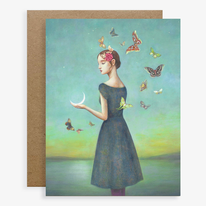 Duy Huynh notecard "A Common Attraction". A woman holds a crescent moon and is surrounded my moths. Card is blank inside.