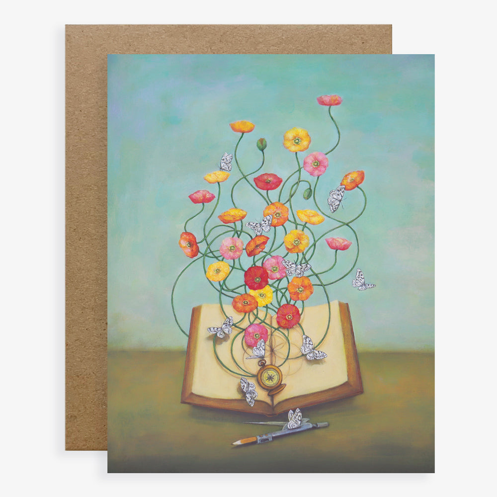 Duy Huynh notecard "Bloom Wherever Planted". Idea butterflies flutter around poppies that bloom from an open book. Other details include a compass for directions and a pencil compass. Card is blank inside.
