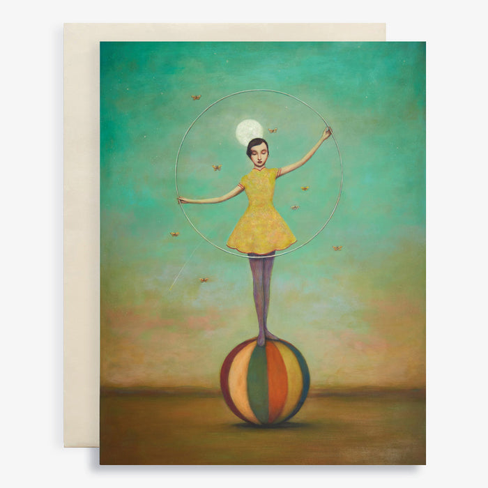 Duy Huynh notecard "Twilight Circus". As woman stands on a colorful ball and hold a hoop under a full moon. Moths flutter around her as star shoots across the sky. Card is blank inside.