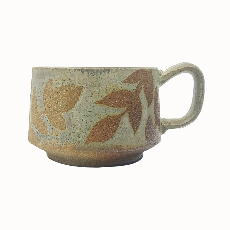 Heather Ossandon handmade, woodfired mug, side view. Cream with light rust botanical pattern.
