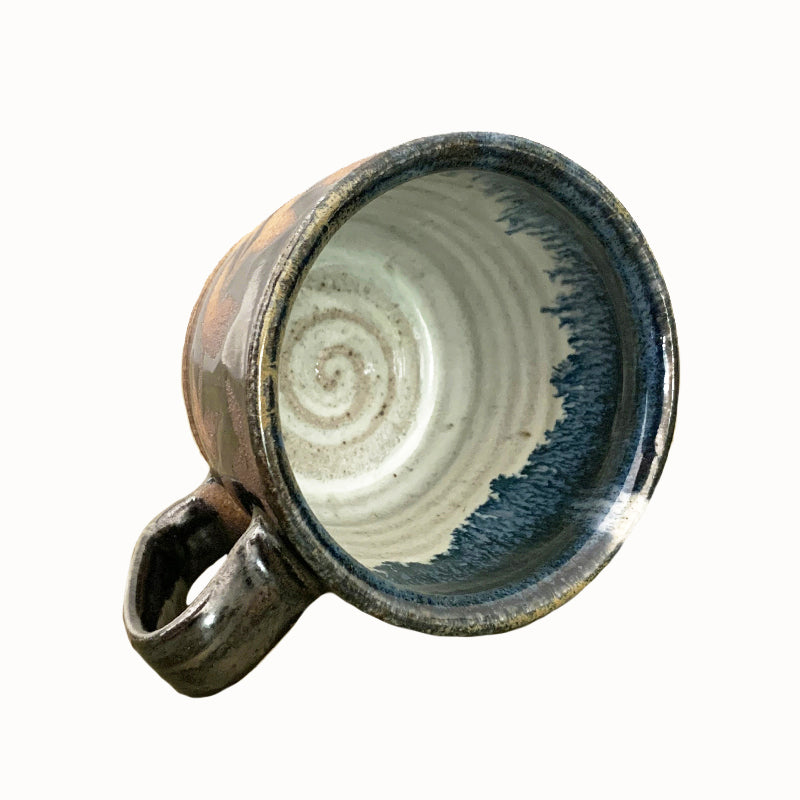 Woodfired creamic mug by Heather Ossandon, black and blue hues with rust flower pattern. Interior view.