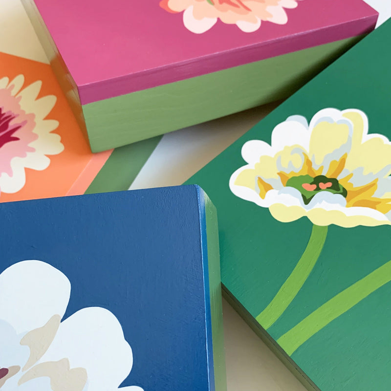 Detail of four colorful daisy paintings by Michele Aschenbrenner.
