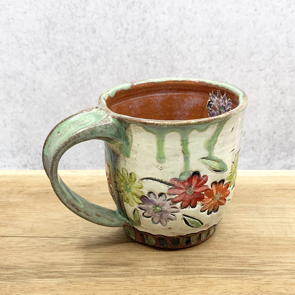 Handmade ceramic mug with flower decoration by Molly Lithgo. Made in North Carolina.