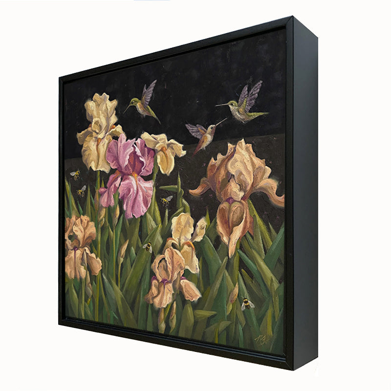 "After Hours Garden Party" painting by Ninalee Irani. 16 inch oil painting on canvas features a night scene with yellow and pink iris flowers, bees and hummingbirds.. The painting is set in a black floater frame. Side view.