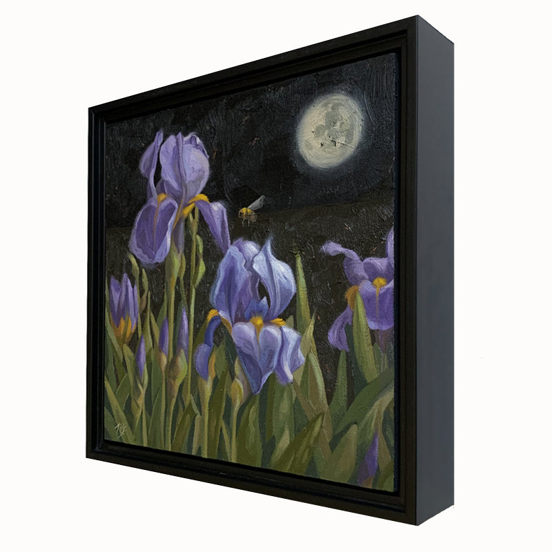 "Moon Flowers" painting by Ninalee Irani. 10 inch oil painting on canvas features a night scene with purple iris flowers and a bee under a full moon. The painting is set in a black floater frame. Side view.