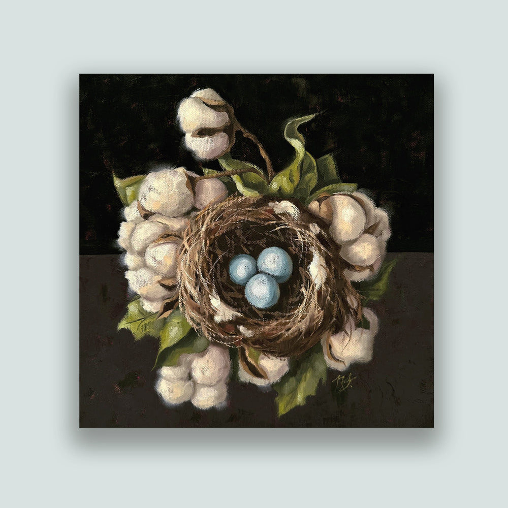 "Cotton Bedding", 10 x 10" oil painting by Ninalee Irani. A nest with three blue eggs is nestled a bed of cotton, with a dark background. Artwork shown on a pale blue wall.