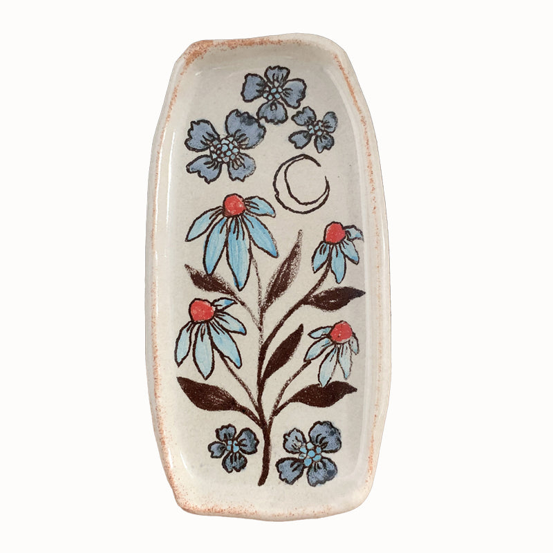 Handmade pottery from Off Menu Pots. Small dish decorated with blue and red flowers, and a crescent moon.
