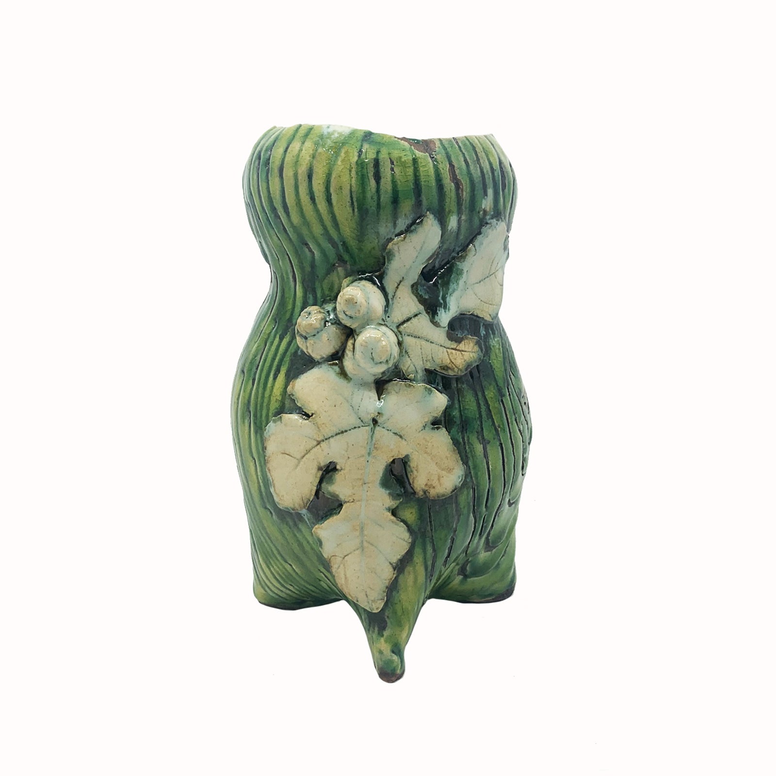 Handmade ceramic vase by artist Paula Smith. Curvy vase, green body with woodgrain detail, decorated with white fig leaves.