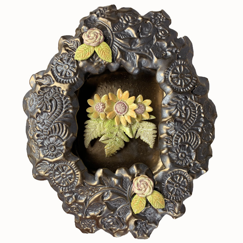 Handmade ceramic wall niche with flower details by Paula Smith. Gunmetal glazed clay with stamped details, with three dimensional yellow flowers and leaves.