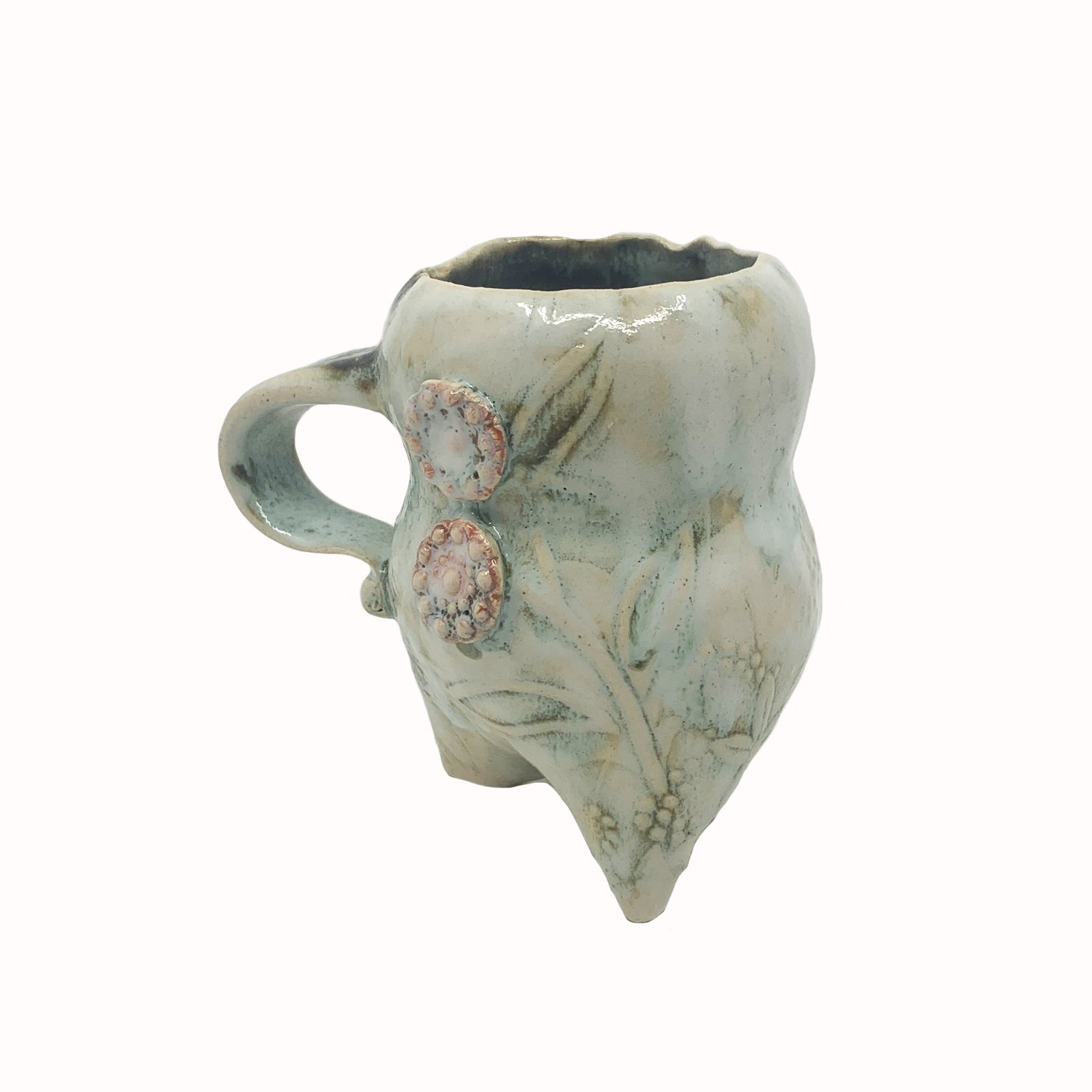 Handmade ceramic cup by artist Paula Smith. Curvy cup with handle, creamy white  body with floral detail, decorated with pink buttons. View 3.