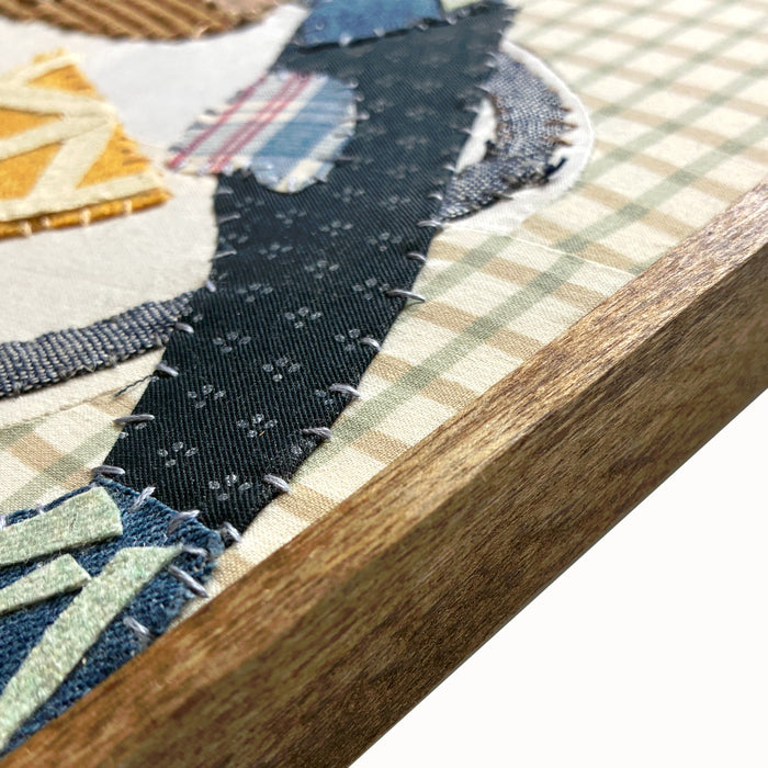 Veggie Plate textile collage by artist Hannah Goff. The artwork is comprised of hand-sewn, reclaimed and recycled fabrics, and features an anchovy, bread, lemon wedges and knife. Finished in a handmade rustic wood frame, side detail view shown.