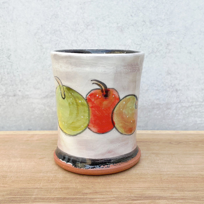 Handmade ceramic cup by NC potter Molly Lithgo. White with red and green apple  decoration. 