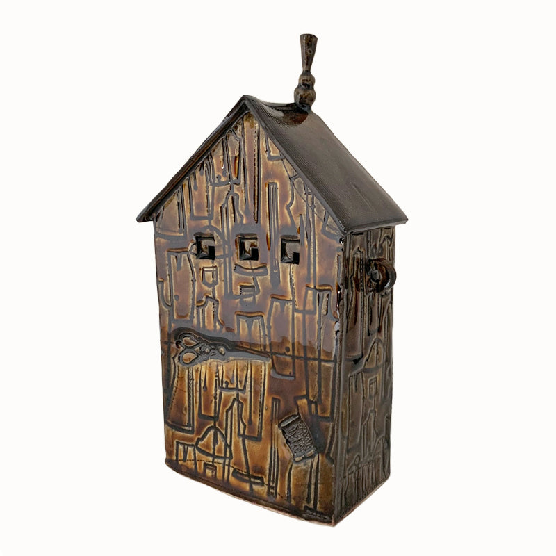 Handmade ceramic house by artist Barbara Chadwick, brown with sewing pattern, sewing machine, scissor and thread details.