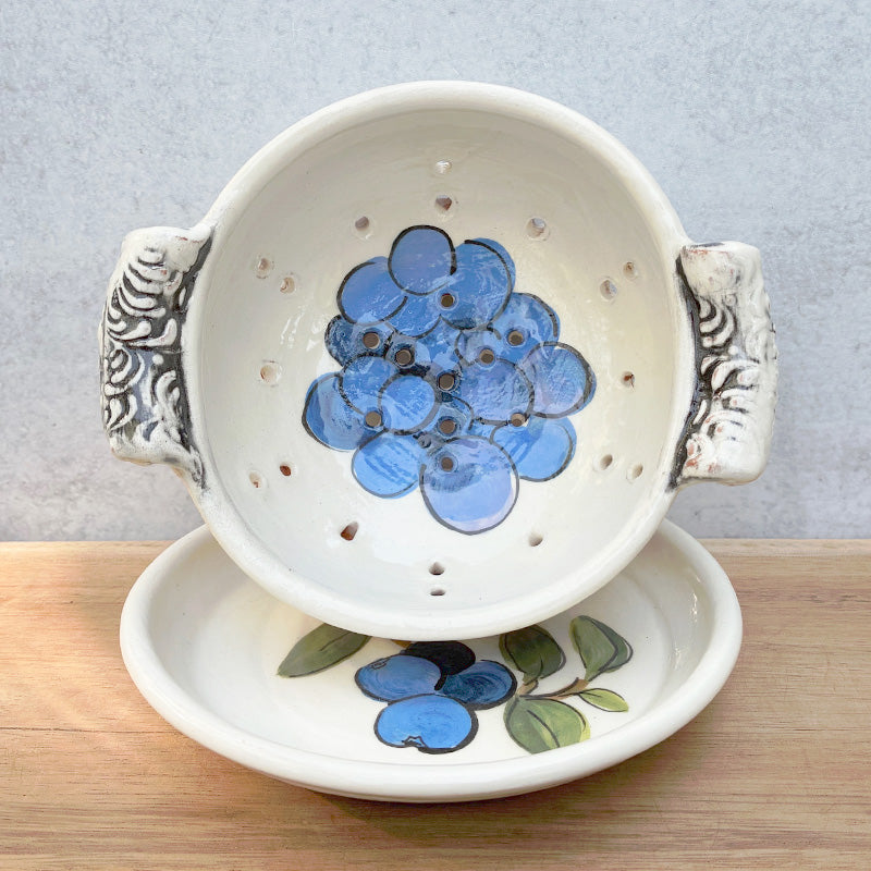 Handmade ceramic berry bowl with blueberry decoration by Molly Lithgo. Interior view with saucer. 