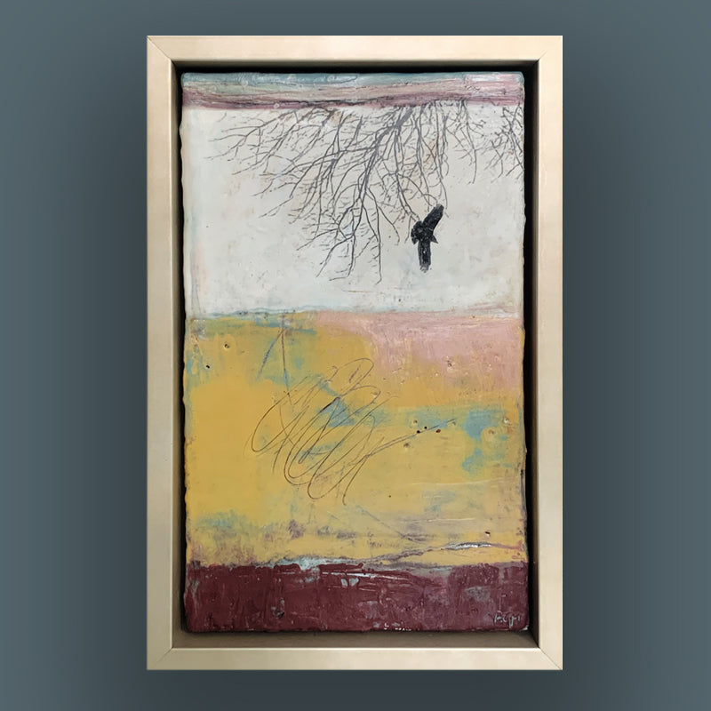 "Flight Patterns" mixed media encaustic painting by Bridgette Guerzon Mills. Framed artwork featuring an abstract textured background in white, pink, yellow and dark red. A tree branches hang from the top down, and a single bird is in flight. Shown on a dark blue wall.