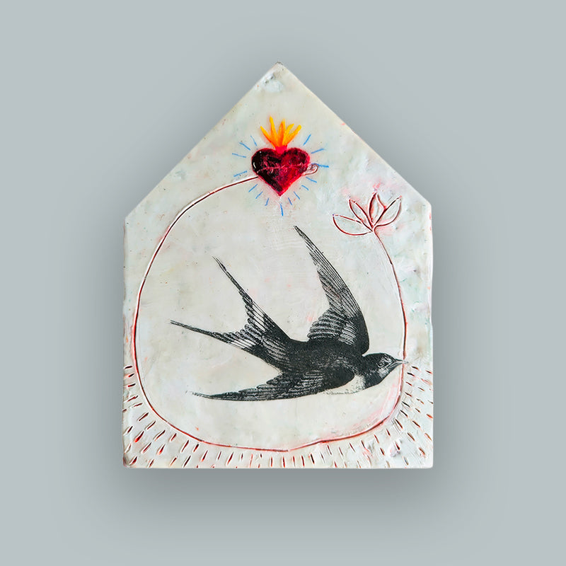 Suggestion


A handcrafted ceramic tile with a house-shaped silhouette, featuring a black swallow bird, a red sacred heart with yellow and orange flames, and red circular line details on a textured off-white background. Displayed on pale blue wall. 