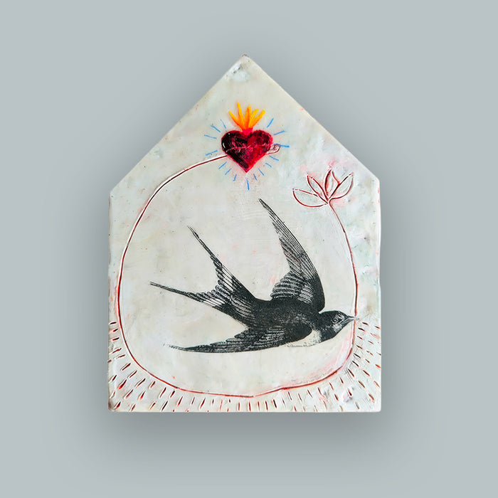 Suggestion


A handcrafted ceramic tile with a house-shaped silhouette, featuring a black swallow bird, a red sacred heart with yellow and orange flames, and red circular line details on a textured off-white background. Displayed on pale blue wall. 