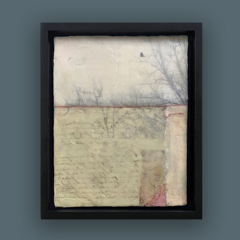"When the Blackbird Flew" painting by Bridgette Guerzon Mills.  Framed  mixed media encaustic artwork with tree silhouettes, bird in flight, vintage papers and red thread. Shown on dark blue wall.