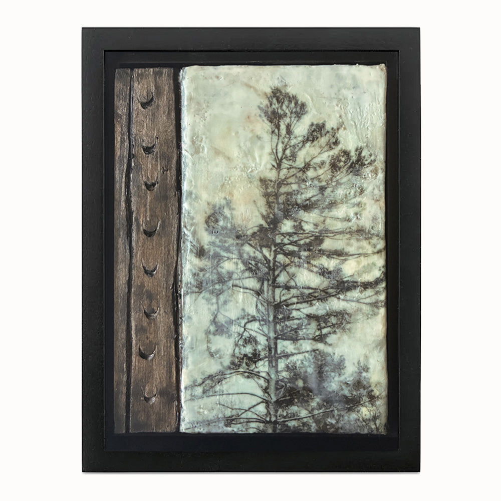 Framed artwork with a tree silhouette and hand carved wood detail. 