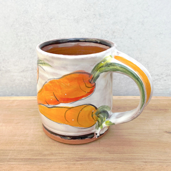 Handmade ceramic mug by NC potter Molly Lithgo. White with carrot  decoration. View with handle detail.