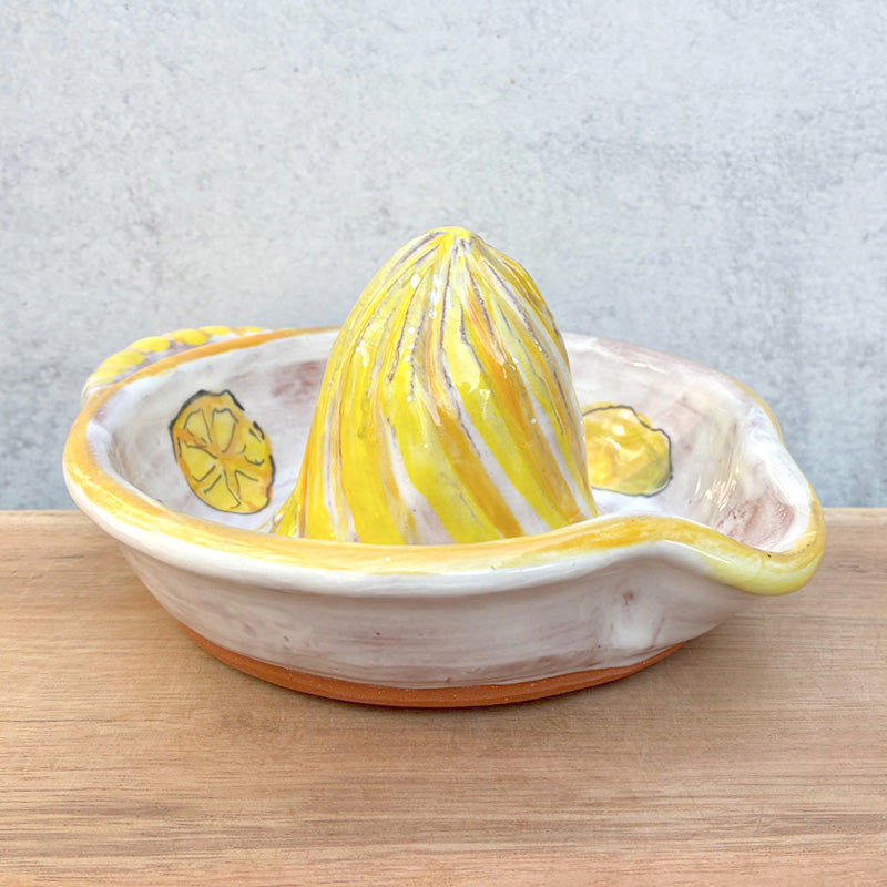 Handmade ceramic juicer with lemon decoration by Molly Lithgo, sitting on wood countertop.