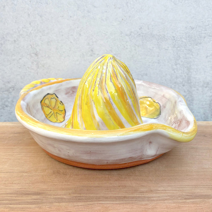 Handmade ceramic juicer with lemon decoration by Molly Lithgo, sitting on wood countertop.