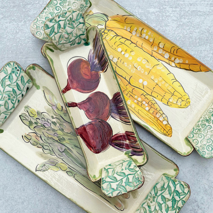 Handmade ceramic serving trays by Molly Lithgo with asparagus, beet and corn decoration.