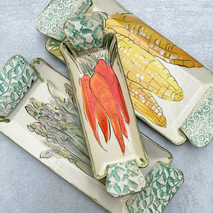 Handmade ceramic serving trays by Molly Lithgo with asparagus, carrot and corn decoration.