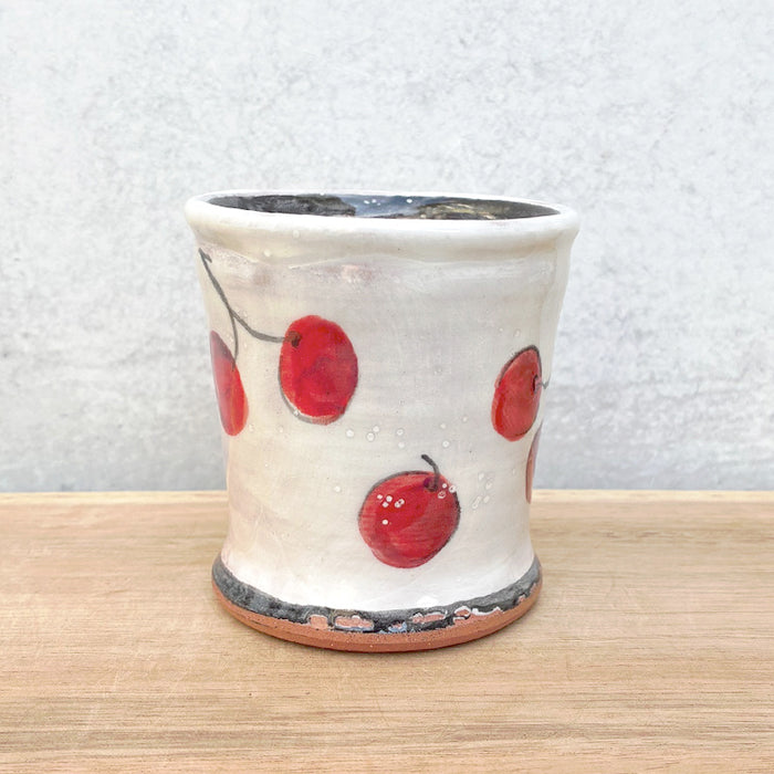 Handmade ceramic cup by NC potter Molly Lithgo. White with red cherry decoration. 