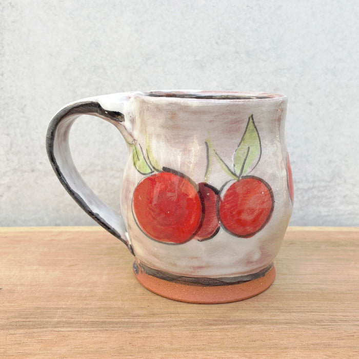 Handmade ceramic mug by NC potter Molly Lithgo. White with cherry decoration. 