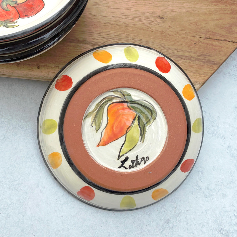 Handmade ceramic bowl with red, orange and green chili pepper decoration by Molly Lithgo. Bottom view with dots and chili peppers on base. 
