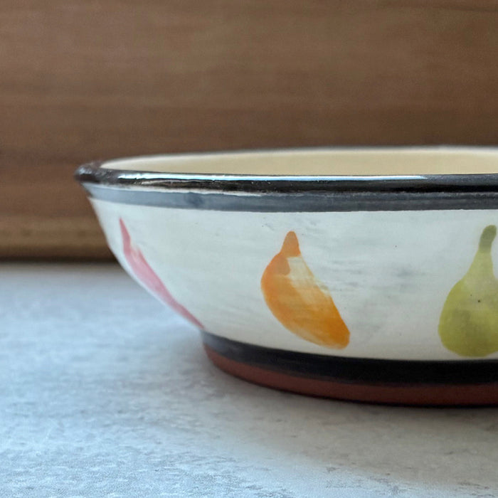 Handmade ceramic bowl with red, orange and green chili pepper decoration by Molly Lithgo. Side view.