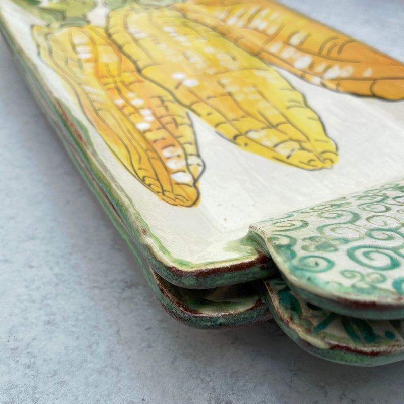 Handmade ceramic serving tray by Molly Lithgo with corn on the cob decoration. Detail with handle. 