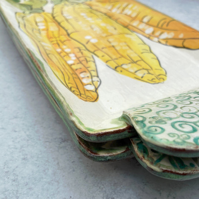 Handmade ceramic serving tray by Molly Lithgo with corn on the cob decoration. Detail with handle. 