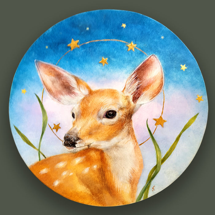 A circular egg tempera and gold leaf painting featuring a young spotted fawn under a starry night sky. Original artwork by Diane Savino, displayed on dark green wall. 