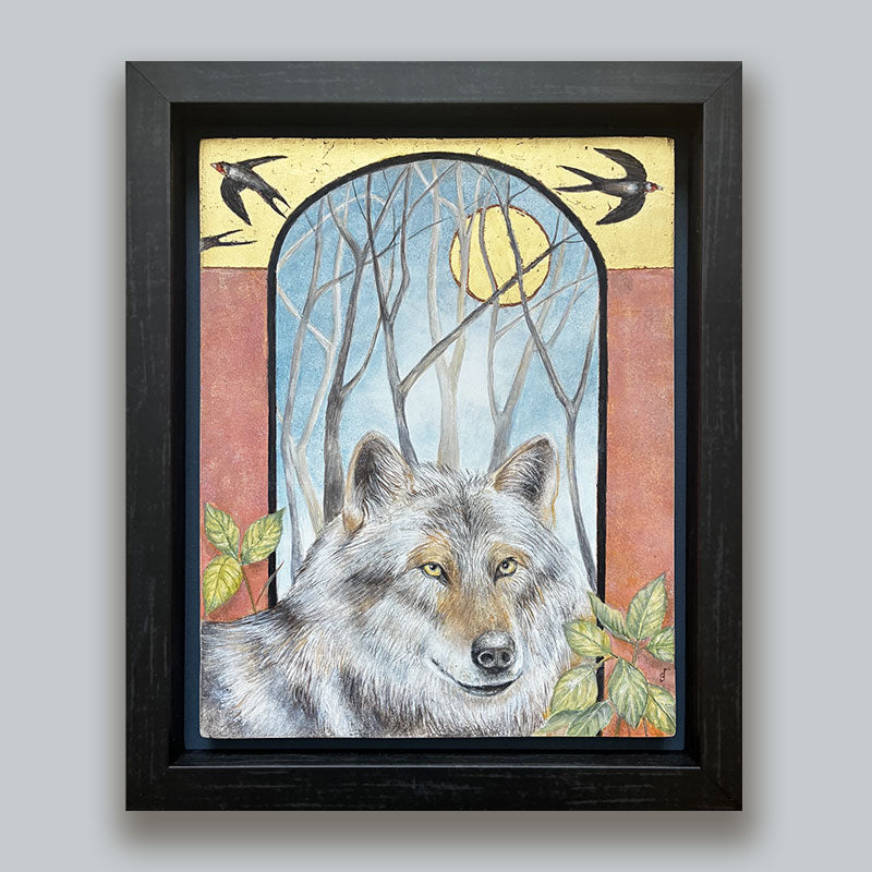 Illustrative egg tempera and gold leaf painting featuring a gray wolf in the foreground, an arched window-like scene with bare trees and a golden moon, two birds at the top, and red-orange side panels. The artwork, by Diane Savino, is set in a dark brown frame and displayed on pale blue wall.