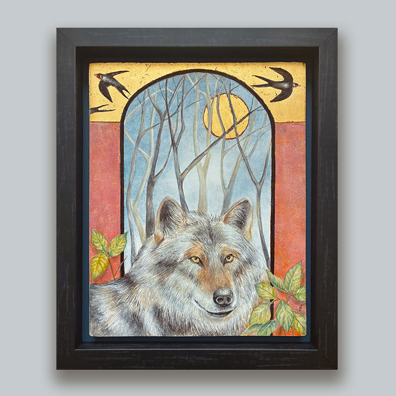 Illustrative egg tempera and gold leaf painting featuring a gray wolf in the foreground, an arched window-like scene with bare trees and a golden moon, two birds at the top, and red-orange side panels. The artwork, by Diane Savino, is set in a dark brown frame and displayed on pale blue wall.