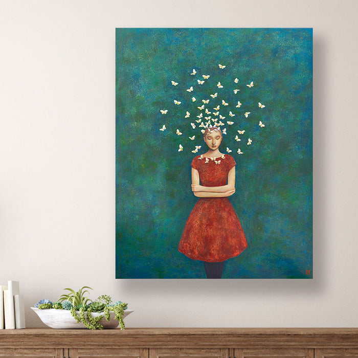 Circle of Serenity, Duy Huynh's  painting of a woman in a red dress standing with arms crossed, with a circle of  Andromeda butterflies circling her head. The mottled dark teal and blue background is filled with subtle botanical textures. The painting is displayed over a wood console table.