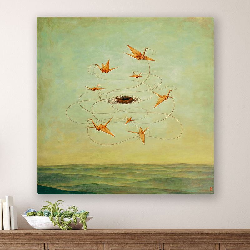 MomentariNest, a 30 x 30" painting by Charlotte NC artist Duy Huynh.  Eight orange origami birds weaving a nest in a greenish yellow sky, over an open landscape. The painting is displayed over a wood console table. 