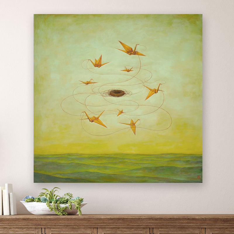 MomentariNest, a 30 x 30" surreal painting by Charlotte NC artist Duy Huynh.  Eight orange origami birds weaving a nest in a greenish yellow sky, over an open landscape. Displayed over wood console table.